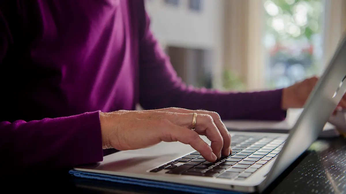 ARCHIV - 01.10.2021, Bayern, München: Eine Frau sitzt zuhause an einem Esstisch und arbeitet an einem Laptop. (Gestellte Szene) Große und kleine Unternehmen in Deutschland gehen beim Homeoffice in unterschiedliche Richtungen. (zu dpa «Große Firmen bieten mehr Homeoffice an - kleine weniger») Foto: Finn Winkler/dpa +++ dpa-Bildfunk +++