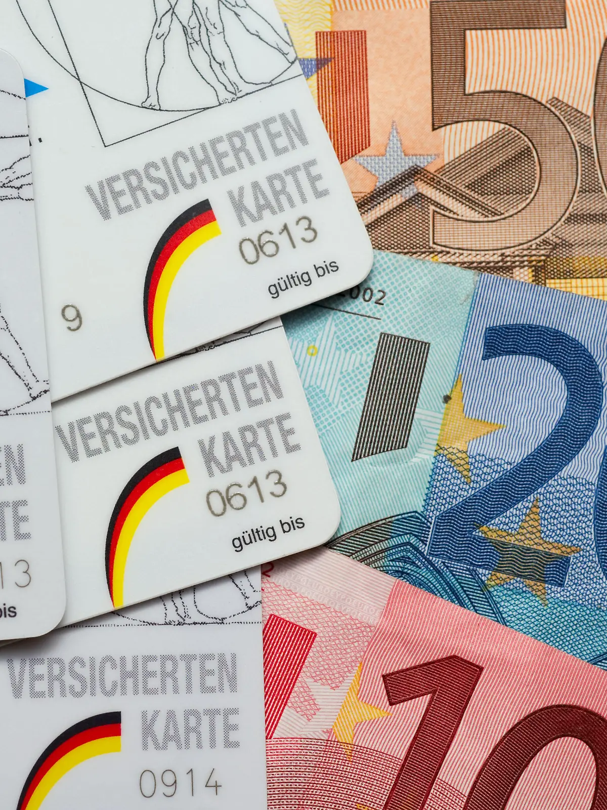 ARCHIV - ILLUSTRATION - Krankenkassen-Karten für Pflichtversicherte liegen neben Euro-Scheinen am 22.09.2010 in einem privaten Haushalt in Frankfurt (Oder). Das Bundeskabinett befasst sich am 10.04.2013 u.a. mit einem Gesetz zur Beseitigung sozialer Überforderung bei Beitragsschulden in der Krankenversicherung. Foto: Patrick Pleul/dpa +++(c) dpa - Bildfunk+++