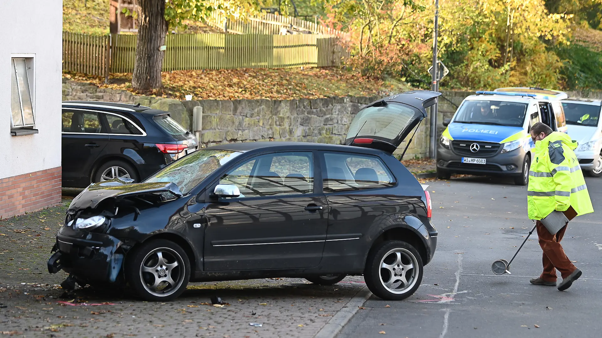 ARCHIV - 29.10.2021, Hessen, Witzenhausen: Ein Polizist untersucht hinter einem schwarzen VW Polo vor einer Kindertagesstätte im Ortsteil Gertenbach den Unfallhergang (zu dpa: «Autofahrer soll vorsätzlich in Schülergruppe gefahren sein»). Foto: Swen Pförtner/dpa +++ dpa-Bildfunk +++