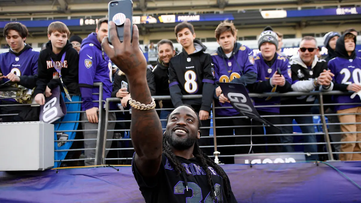 FILE - Baltimore Ravens running back Alex Collins (34) takes a photo with fans before an NFL wild-card playoff football game against the Los Angeles Chargers, Jan. 6, 2019, in Baltimore. Former NFL running back Collins, who played five seasons for the Seattle Seahawks and the Ravens after a terrific college career at Arkansas, has died. He was 28. The Seahawks released a statement from Collins' family that said he died Monday, Aug. 14, 2023. (AP Photo/Nick Wass, File)