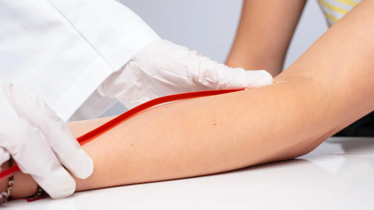 Ein Arzt legt eine Kanüle auf den Arm eines Patienten