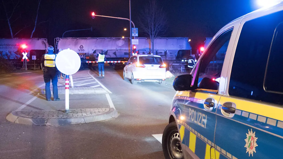 15.02.2023, Nordrhein-Westfalen, Köln: Polizei steht an einem Bahnübergang im Kölner Stadtteil Ossendorf. Hier wurde ein 15-jähriger Schüler am Nachmittag von einem Güterzug erfasst und schwer am Kopf verletzt. Lebensgefahr bestehe aber nicht, sagte ein Polizeisprecher. Nach ersten Ermittlungen soll der Jugendliche trotz roter Ampel, akustischen Signals und geschlossener Schranke mit seinem Fahrrad über die Gleise gefahren sein, berichtete die Polizei. Foto: Vincent Kempf/-/dpa +++ dpa-Bildfunk +++