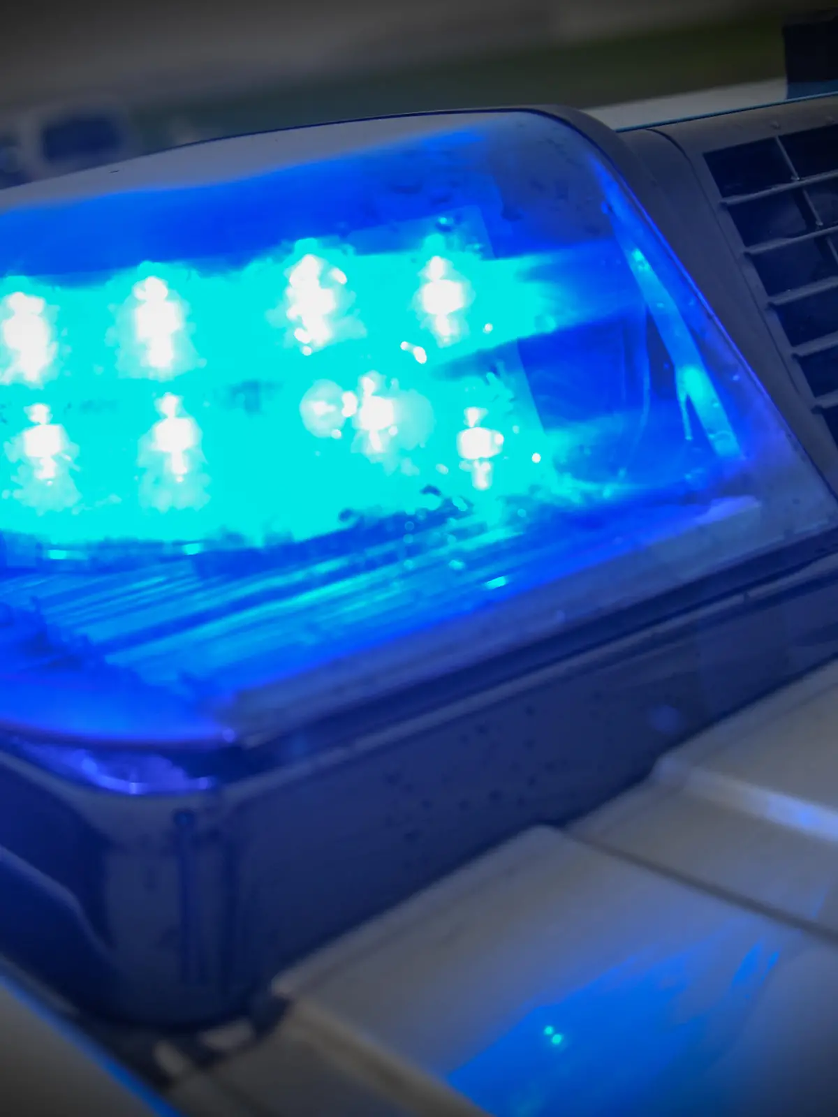 Ein Einsatzfahrzeug mit eingeschaltetem Blaulicht steht an einer Unfallstelle.