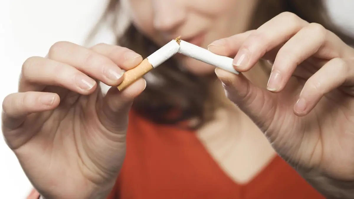Junge Frau bricht eine Zigarette durch