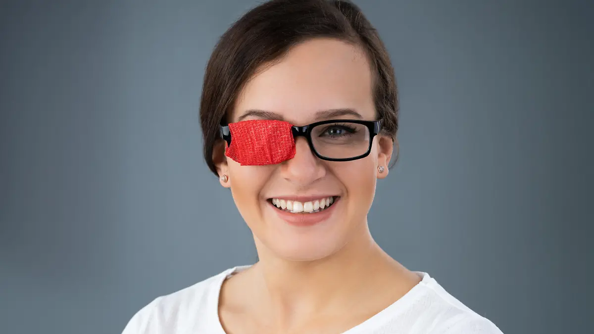 Frau mit zugeklebtem Brillenglas (Okklusionsbehandlung)