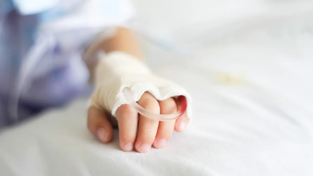 Saline intravenous (iv) drip in a Children's patient hand