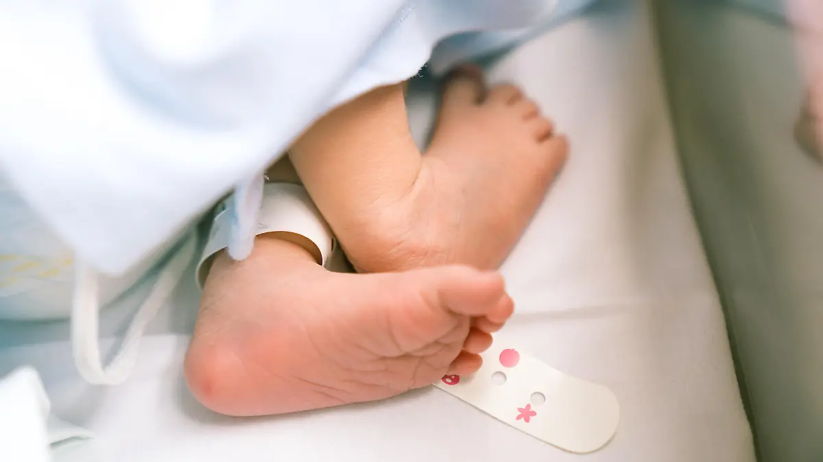 Baby liegt im Krankenhausbett.
