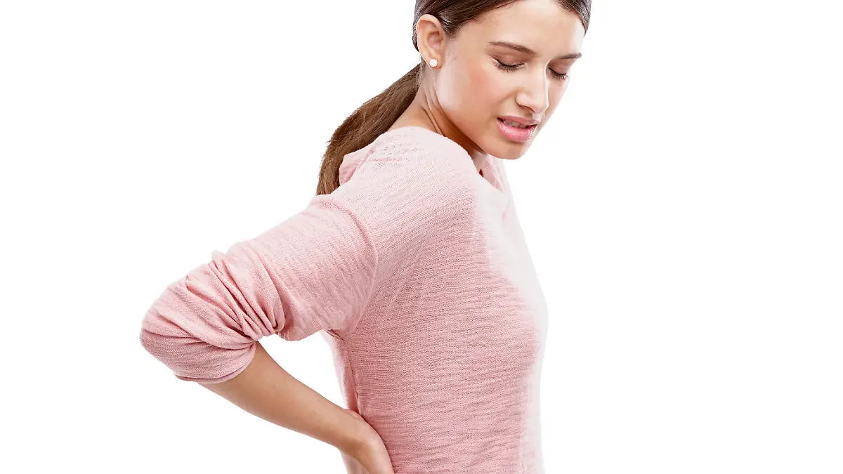 Studio shot of an attractive young woman experiencing back pain
