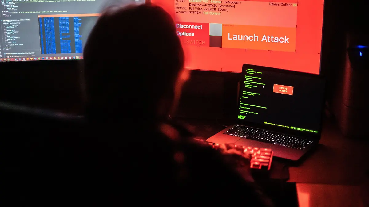 ARCHIV - 25.02.2022, Nordrhein-Westfalen, Bad Oeynhausen: ILLUSTRATION - Ein Mann sitzt vor Bildschirmen, die Hacker-Programme und eine fiktive Fernlösch-Software zeigen. Die Furcht vor einem kriminellen Cyberangriff bleibt trotz hoher Inflation, Energiesorgen und Ukraine-Kriegs die größte Sorge für Manager und Sicherheitsfachleute. (Zu dpa «Allianz: Cyberkriminalität bleibt größte Gefahr für Unternehmen») Foto: Lino Mirgeler/dpa +++ dpa-Bildfunk +++