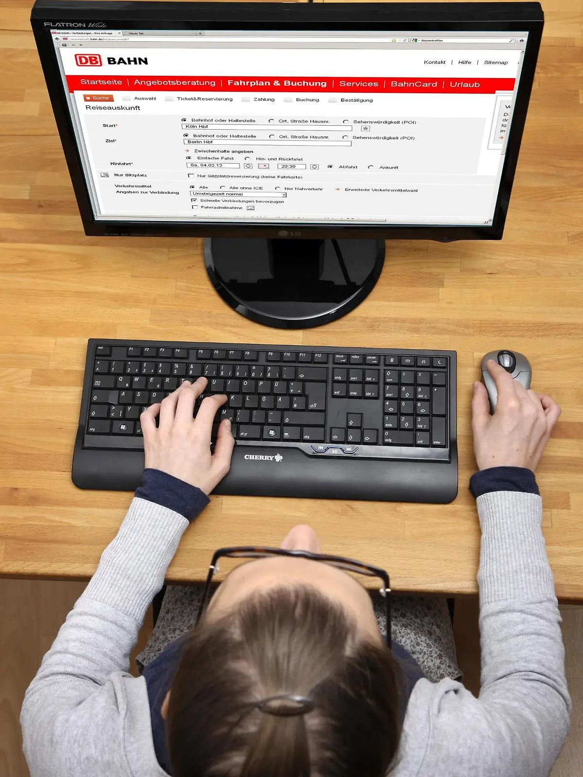 Eine Frau kauft online ein Ticket bei der Deutschen Bahn