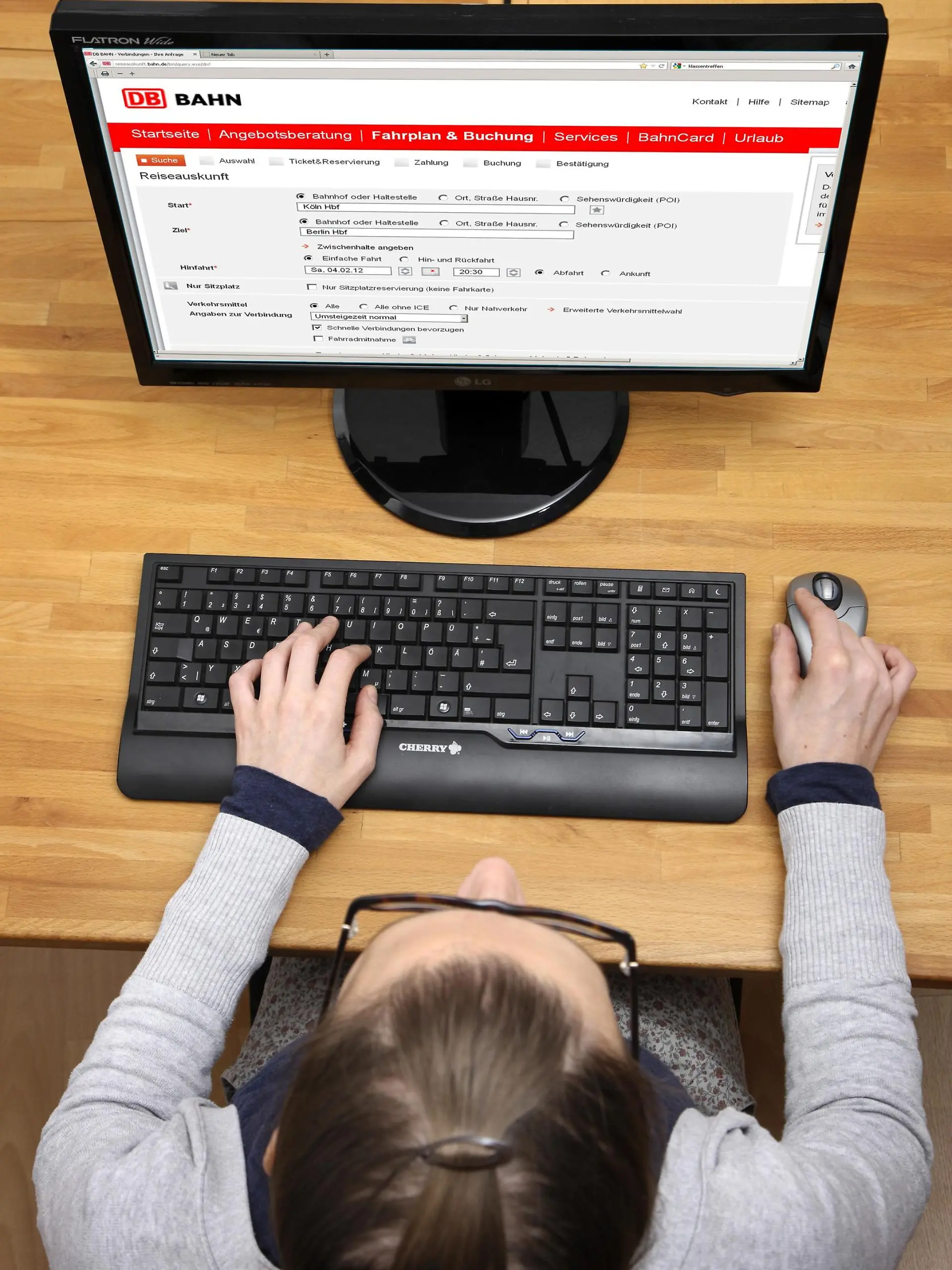 Eine Frau kauft online ein Ticket bei der Deutschen Bahn