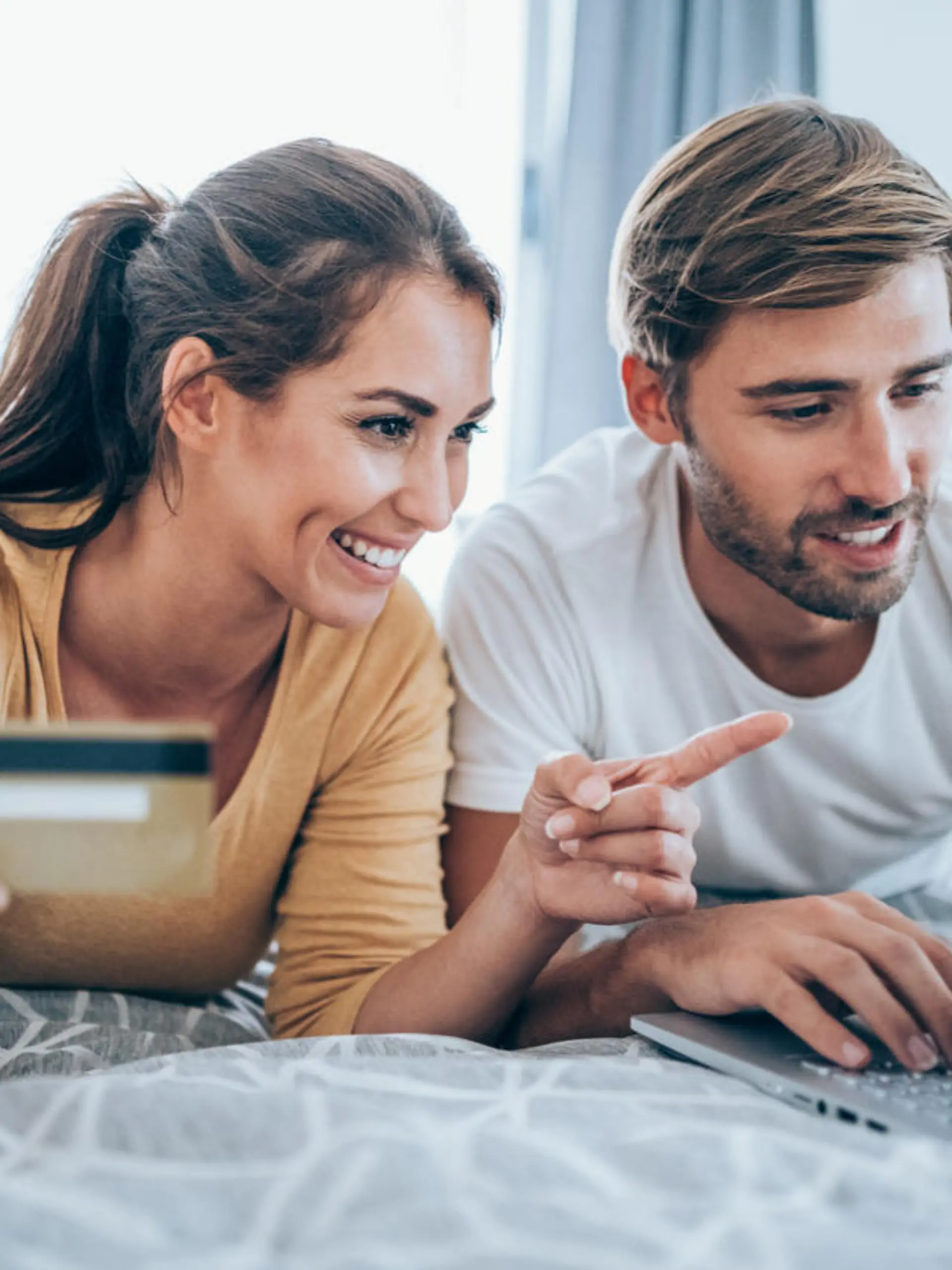 Young cheerful couple shopping online at home. Couple shopping online with credit card and laptop.