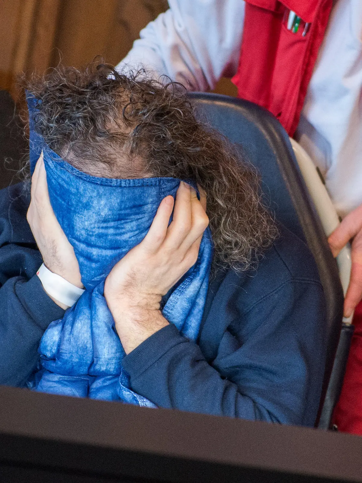 Der 43 Jahre alte Angeklagte wird am 09.01.2018 in Schwerin (Mecklenburg-Vorpommern) von einer Helferin des Deutschen Roten Kreuzes in das Landgericht gebracht. Die Staatsanwaltschaft wirft dem ehemaligen Mitarbeiter eines Schweriner Jugendtreffs vor, während seiner Tätigkeit in dem Treff fünf Jungen im Alter zwischen acht und dreizehn Jahren missbraucht zu haben. (ACHTUNG: Das Armband des Angeklagten wurde aus persönlichkeitsrechtlichen Gründen unkenntlich gemacht) Foto: Daniel Bockwoldt/ZB/dpa +++(c) dpa - Bildfunk+++