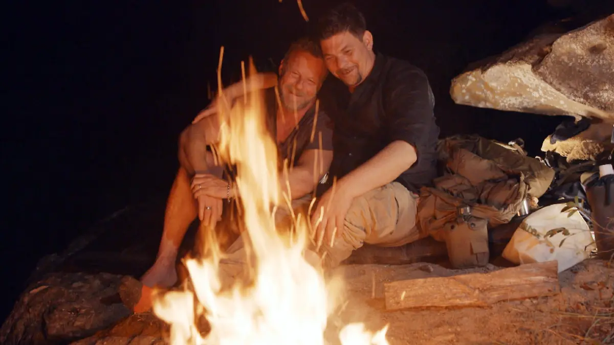 Jenke von Wilmsdorff und Tim Mälzer sitzen am Lagerfeuer