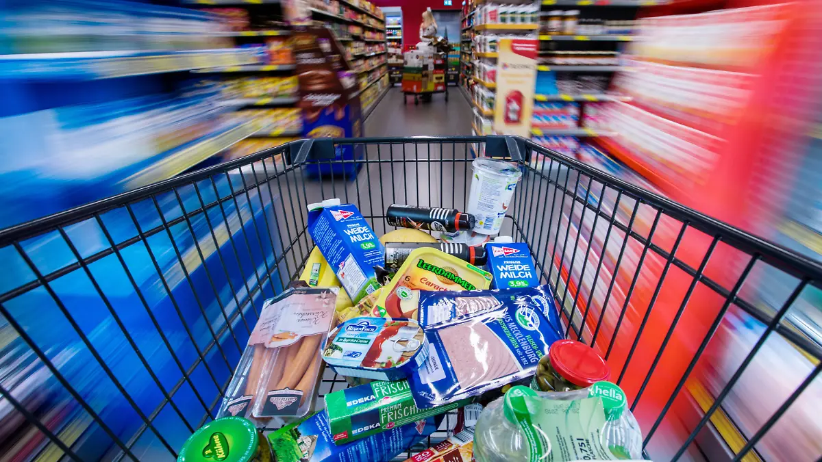 ARCHIV - Ein Einkaufswagen mit Lebensmitteln wird am 30.11.2017 in Schwerin (Mecklenburg-Vorpommern) durch die Regalreihen in einem Supermarkt geschoben. (Zu dpa "Schlecht fürs Portemonnaie: Inflation zieht wieder an" vom 16.01.2018) Foto: Jens Büttner/dpa-Zentralbild/dpa +++(c) dpa - Bildfunk+++