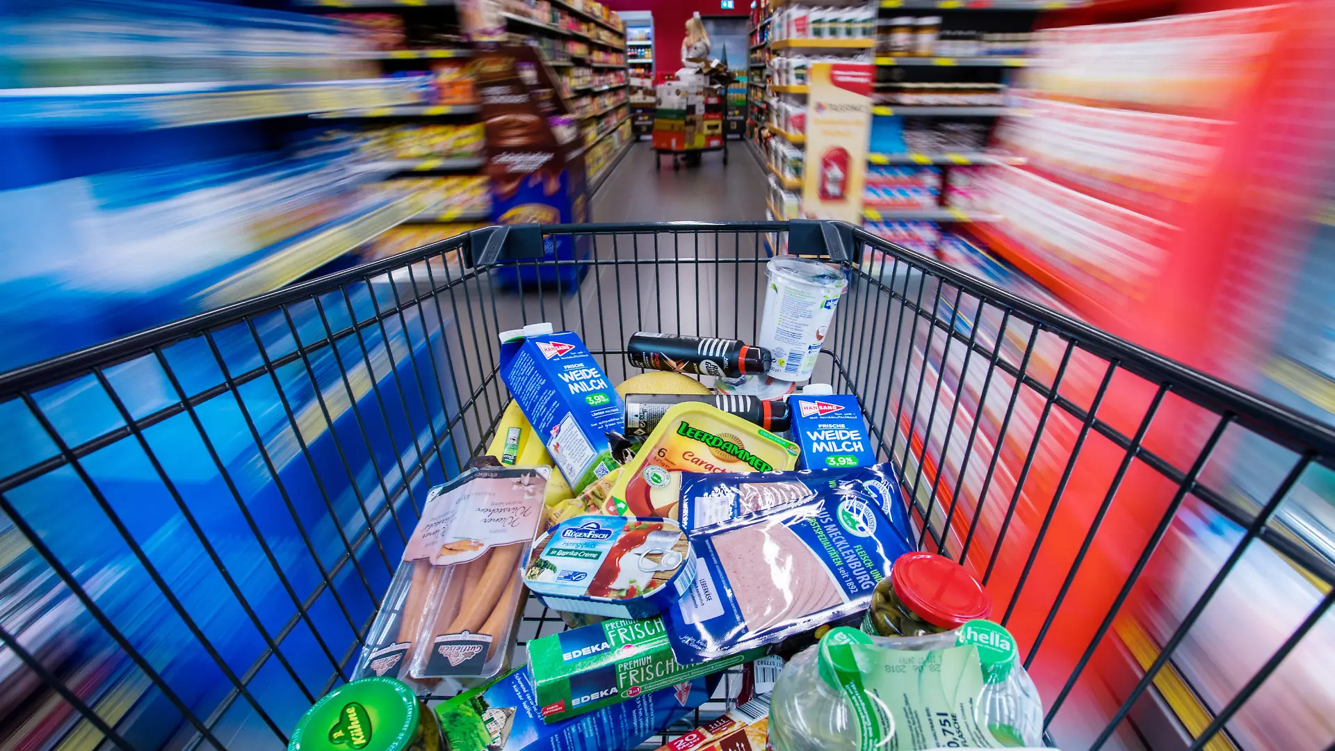ARCHIV - Ein Einkaufswagen mit Lebensmitteln wird am 30.11.2017 in Schwerin (Mecklenburg-Vorpommern) durch die Regalreihen in einem Supermarkt geschoben. (Zu dpa "Schlecht fürs Portemonnaie: Inflation zieht wieder an" vom 16.01.2018) Foto: Jens Büttner/dpa-Zentralbild/dpa +++(c) dpa - Bildfunk+++