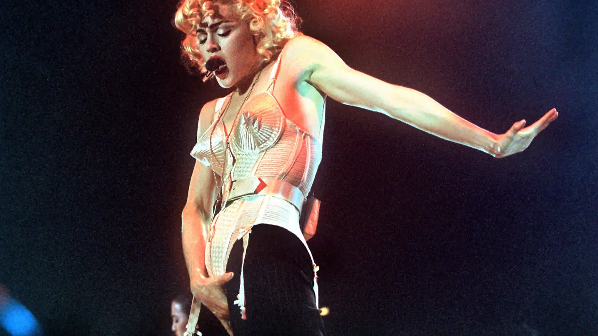 Die Geste kennt man von Michael Jackson... In "spitze" Dessous gekleidet tritt die amerikanische Sängerin und Schauspielerin Madonna am 17. Juli 1990 in Dortmund auf. Ein ähnliches schwarzes Bustier mit goldenen Quasten, das die Pop-Ikone  während ihrer "Who's That Girl"-Konzert-Tournee getragen hatte, wird ab dem 18.7.2001 bei Sothebys versteigert. Anlässlich Madonnas 20-jährigem Jubiläum auf der Showbühne soll das modische Stück bei einer Internet-Auktion (unter Sothebys.com) unter die Leute gebracht werden. Nicht zuletzt die Auftritte von Madonna machten das Tragen von Unterwäsche als "Oberbekleidung" salonfähig.