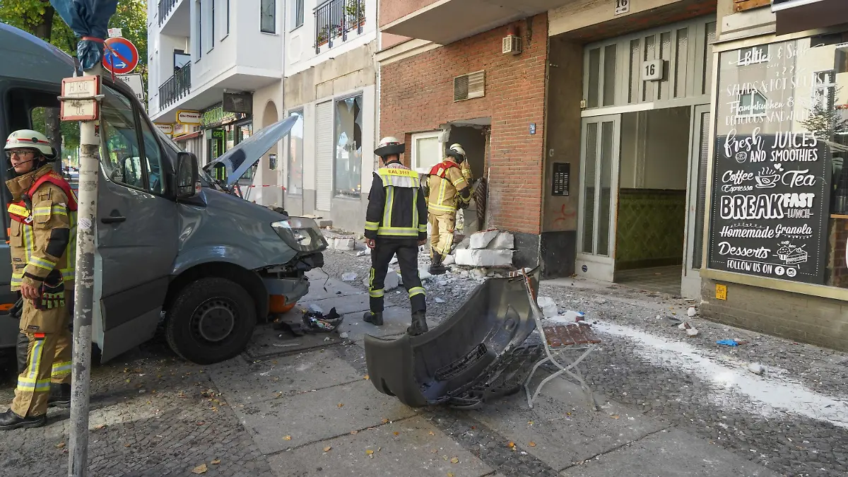 05.10.2018, Berlin: Einsatzkräfte der Feuerwehr stehen an einer beschädigten Hauswand und  Transporter. Das Fahrzeug soll in ein Cafe gefahren sein und dabei fünf Personen verletzt haben. Foto: Jörg Carstensen/dpa +++ dpa-Bildfunk +++