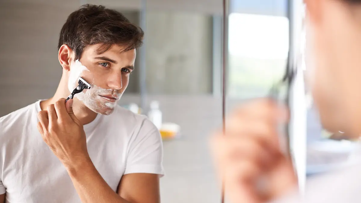 Mann schneidet Bart mit Nassrasierer