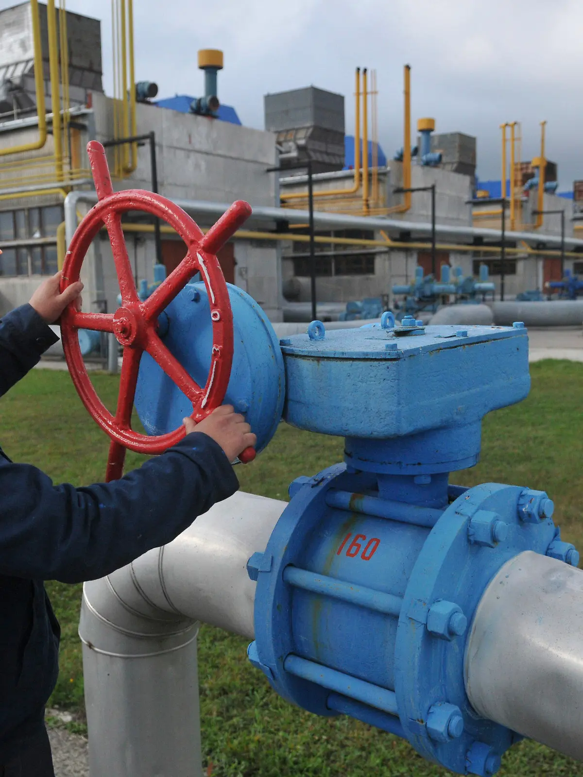 ARCHIV - 07.10.2015, Ukraine, Wolowez: Ein Arbeiter dreht an einem roten Rad an der Erdgasverdichterstation. Foto: Pavlo Palamarchuk/AP/dpa +++ dpa-Bildfunk +++