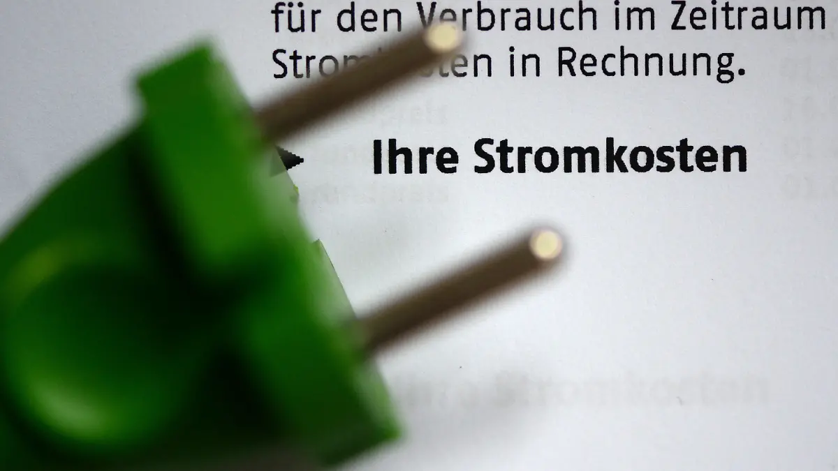 ILLUSTRATION - Ein grüner Stromstecker liegt am 03.11.2013 in Berlin auf einer Stromrechnung. Foto: Jens Kalaene/dpa (Zu dpa "Kritik an versteckten Preiserhöhungen bei Strom und Gas" vom 27.03.2016) +++(c) dpa - Bildfunk+++