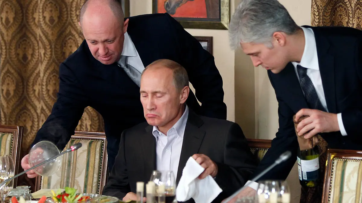 FILE - Businessman Yevgeny Prigozhin, left, serves food to Russian Prime Minister Vladimir Putin, center, during dinner at Prigozhin's restaurant outside Moscow, Russia, Friday, Nov. 11, 2011. Russia has engaged in under-the-radar military operations in at least half a dozen countries in Africa in the last five years using a shadowy mercenary force, Wagner, analysts say is loyal to President Vladimir Putin. The United States identifies Prigozhin as Wagner's financer. (AP Photo/Misha Japaridze, Pool, File)