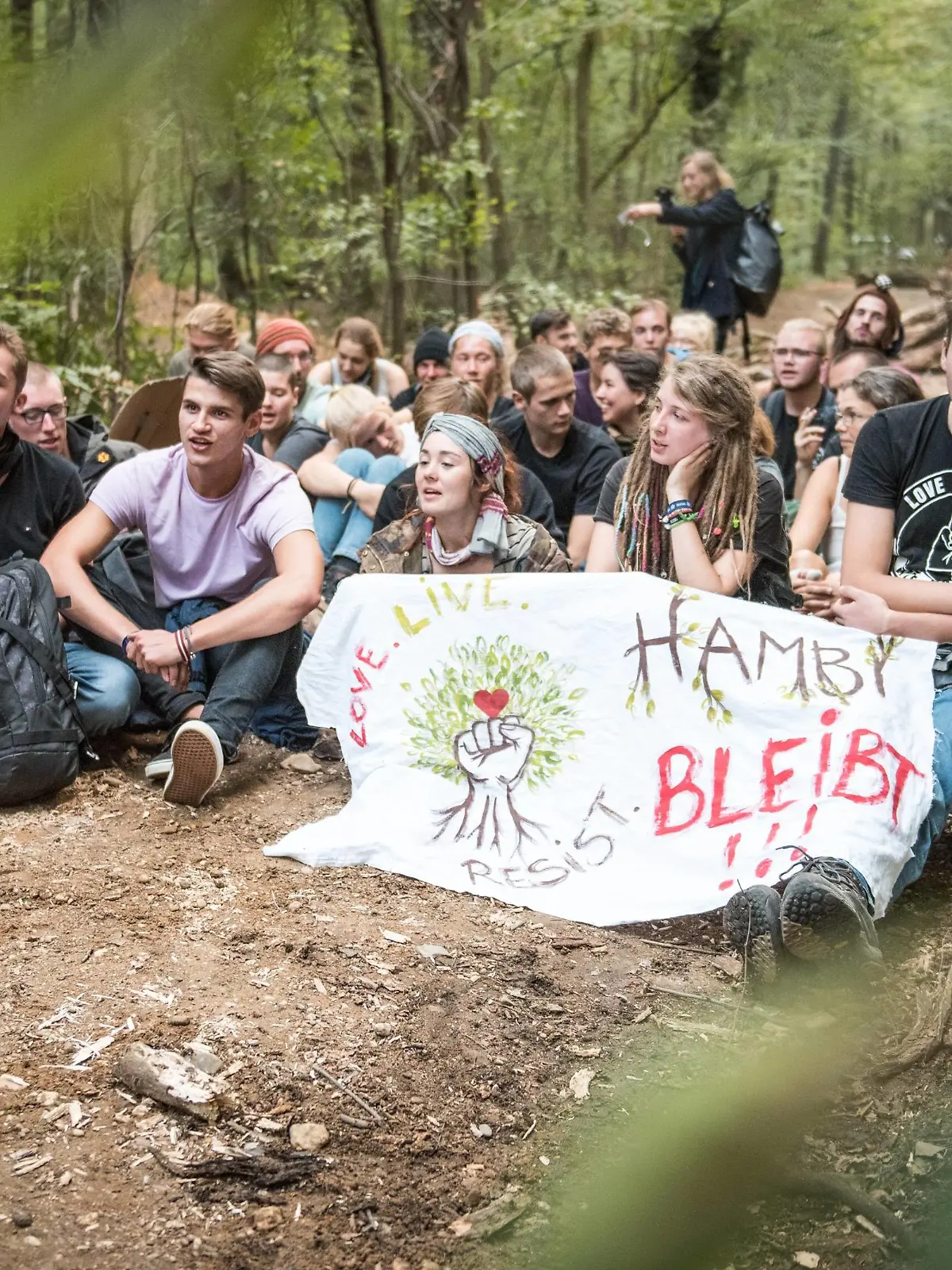 Waldspaziergang im Hambacher Forst & ziviler Ungehorsam Aktivisten mit Transparent: Hambi bleibt! blockieren eine Straße im Wald. *** Forest walk in the Hambacher Forst civil disobedience activists with transparent Hambi remains blocking a road in the forest  