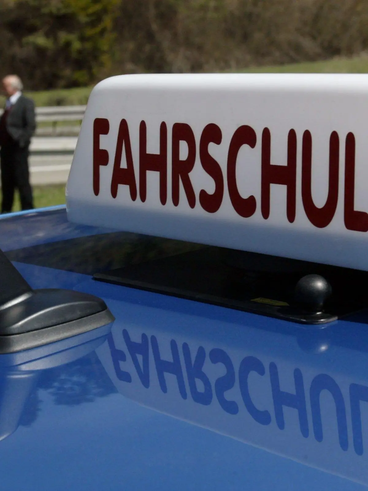 Fahrlehrer Christoph Hennings (M) erklärt zwei Schülern am Mittwoch (21.04.2004) in Villingen-Schwenningen (Schwarzwald-Baar-Kreis) während einer Autofahrt die Funktionen einer Notrufsäule. Im Vordergrund ist ein Schild mit der Aufschirft "Fahrschule" zu sehen. Gegen den Führerschein mit 17 hat sich der Fahrlehrerverband Baden-Württemberg ausgesprochen. Dagegen befürworte der Verband das begleitete Fahren von Führerscheinneulingen. Foto: Patrick Seeger dpa/lsw