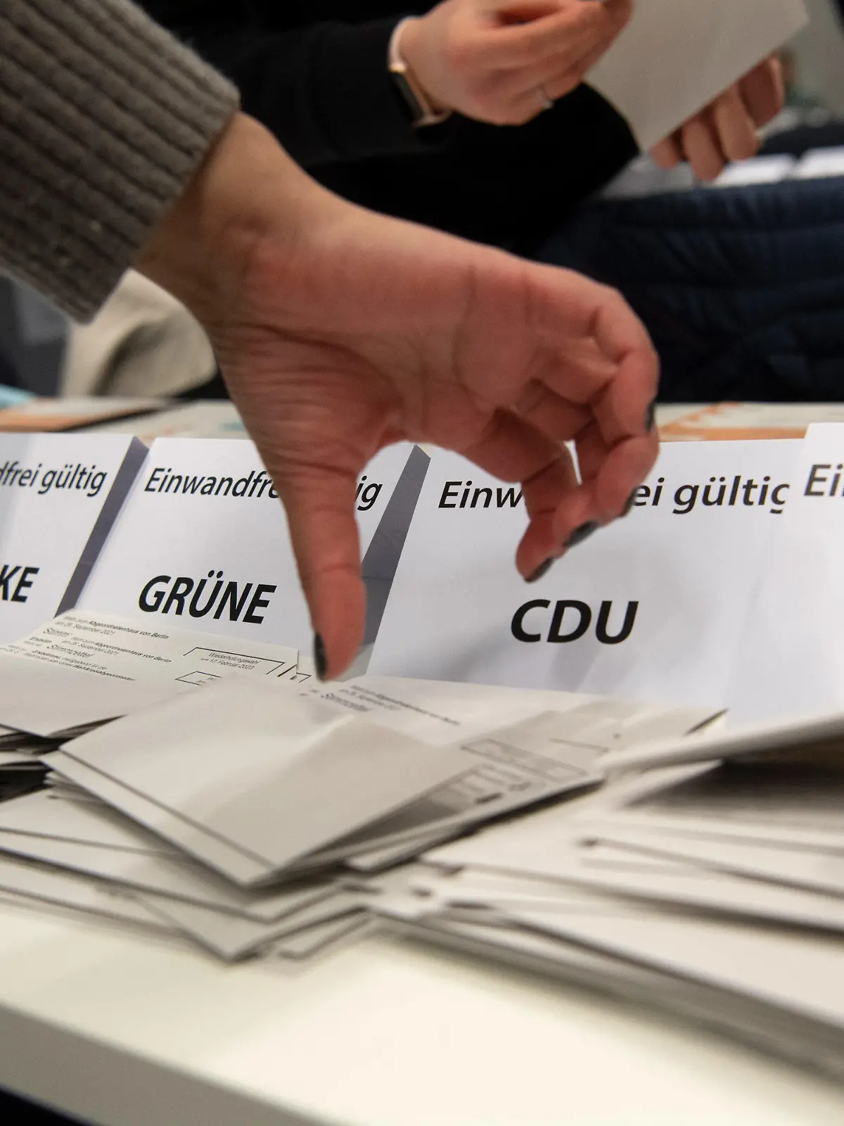 12.02.2023, Berlin: Wahlhelfer sichten im City Cube nach der wiederholten Wahl die Stimmzettel der Briefwähler. Die im Nachhinein vom Berliner Verfassungsgerichtshof für ungültig erklärte Wahl zum 19. Abgeordnetenhaus von Berlin vom 26. September 2021 wurde am Sonntag wiederholt. Foto: Paul Zinken/dpa +++ dpa-Bildfunk +++