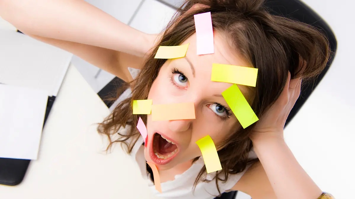 Überforderte Büroangestellte mit vielen Post-Its im Gesicht - overworked clerk with many post-its on the face Keine Weitergabe an Drittverwerter.