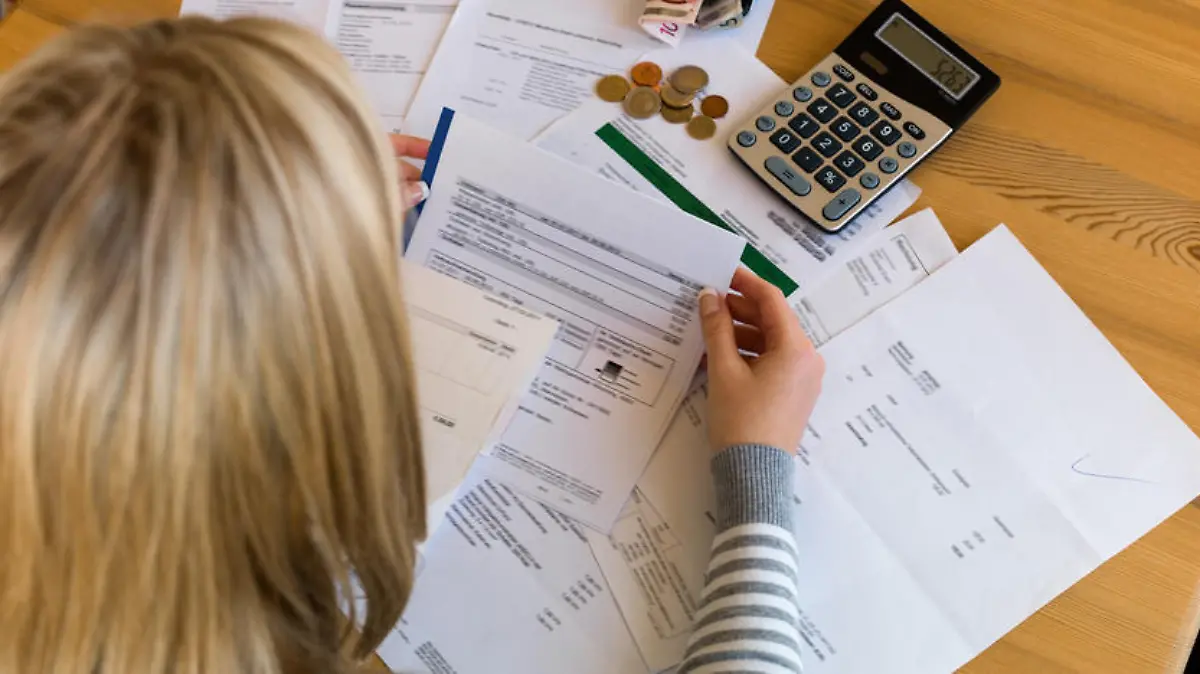 Eine Frau mit offenen Rechnungen hat viele Schulden. Arbeitslosigkeit und Privatkonkurs