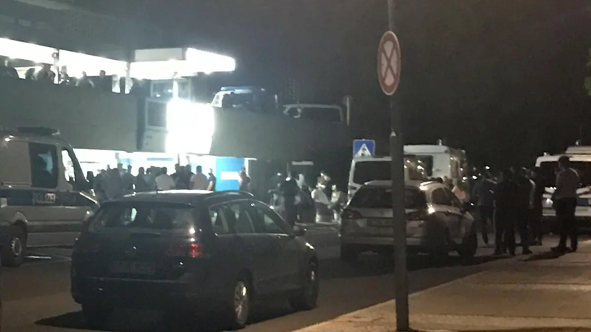 09.09.2018, Berlin: Zahlreiche Menschen haben sich vor dem Benjamin Franklin Klinikum versammelt. Ein 36-Jähriger ist am Tempelhofer Feld in Berlin-Neukölln von mehreren Schüssen getötet worden. Der zunächst lebensgefährlich verletzte Mann wurde am frühen Sonntagabend in ein Krankenhaus gebracht, wo er später starb, wie die Polizei bestätigte. Beamte bewachten das Gebäude mit einem Großaufgebot. Nach unbestätigten Informationen mehrerer Medien soll es sich bei dem Opfer um ein polizeibekanntes Mitglied einer arabischen Großfamilie handeln. (bestmögliche Qualität) Foto: Paul Zinken/dpa +++ dpa-Bildfunk +++