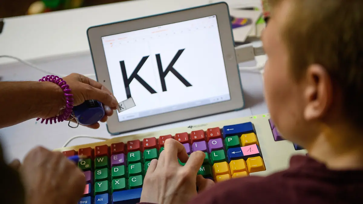 ARCHIV - 17.11.2017, Baden-Württemberg, Korb: SYMBOLFOTO - Eine Therapeutin übt mit einem autistischen Kind das Erkennen und Schreiben von Buchstaben auf einer Tastatur. (zu dpa «Schule, Kindergarten und Autismus - Kongress in Gera») Foto: Sebastian Gollnow/dpa +++ dpa-Bildfunk +++