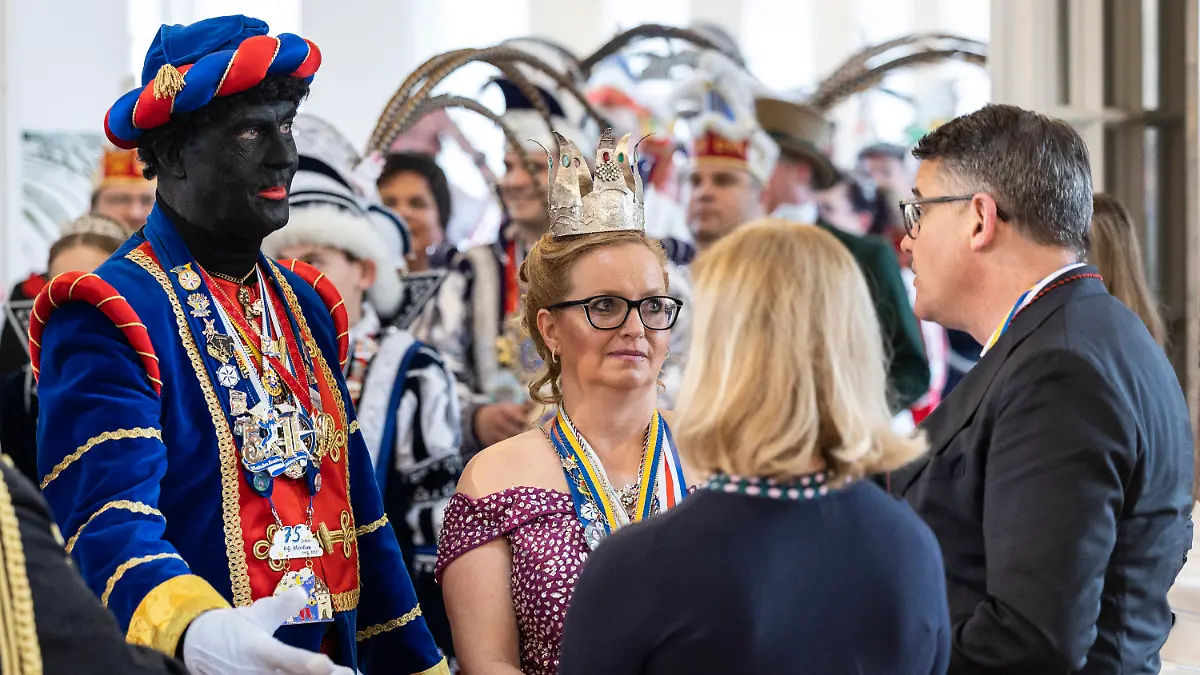 11.02.2023, Hessen, Wiesbaden: Ein von der 1. Ober-Mörler Karnevalsgesellschaft «Mörlau» neben anderen Entstandten schwarz angemalter Mann (l) spricht mit Boris Rhein (CDU, r), Ministerpräsident von Hessen. Die von dem Verein als «Mohr» bezeichnete Figur gilt als Symbol der Ober-Mörlener Fastnacht und findet sich sowohl im Wappen der Karnevalsgesellschaft als auch in dem der Wetterau-Gemeinde Ober-Mörlen. Der Regierungschef dankte den Prinzenpaaren und ihrem Hofstaat stellvertretend für das ehrenamtliche Engagement aller Fastnachter und Karnevalisten in Hessen. Foto: Hannes Albert/dpa +++ dpa-Bildfunk +++