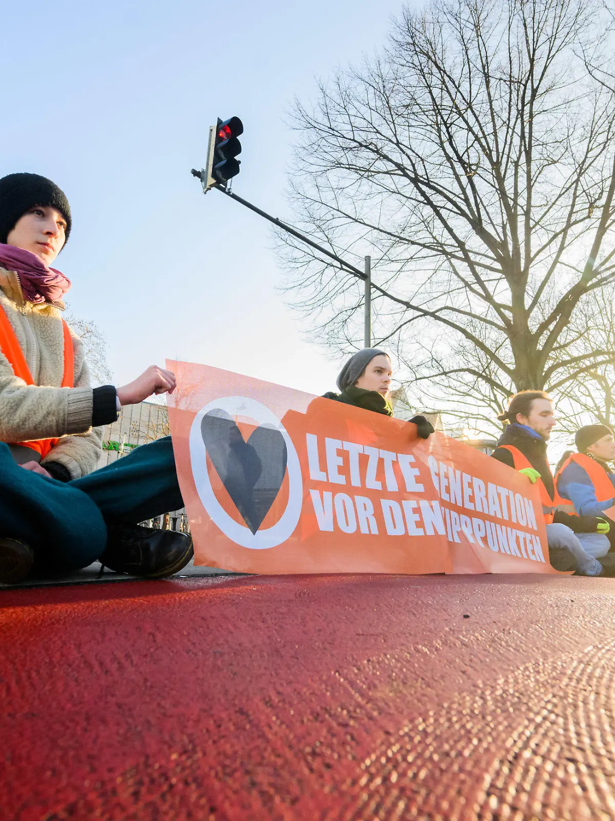dpatopbilder - 14.02.2023, Niedersachsen, Hannover: Aktivisten der Gruppierung «Letzte Generation» haben sich in der Innenstadt teils auf der Straße festgeklebt und blockieren den Verkehr. Foto: Julian Stratenschulte/dpa +++ dpa-Bildfunk +++