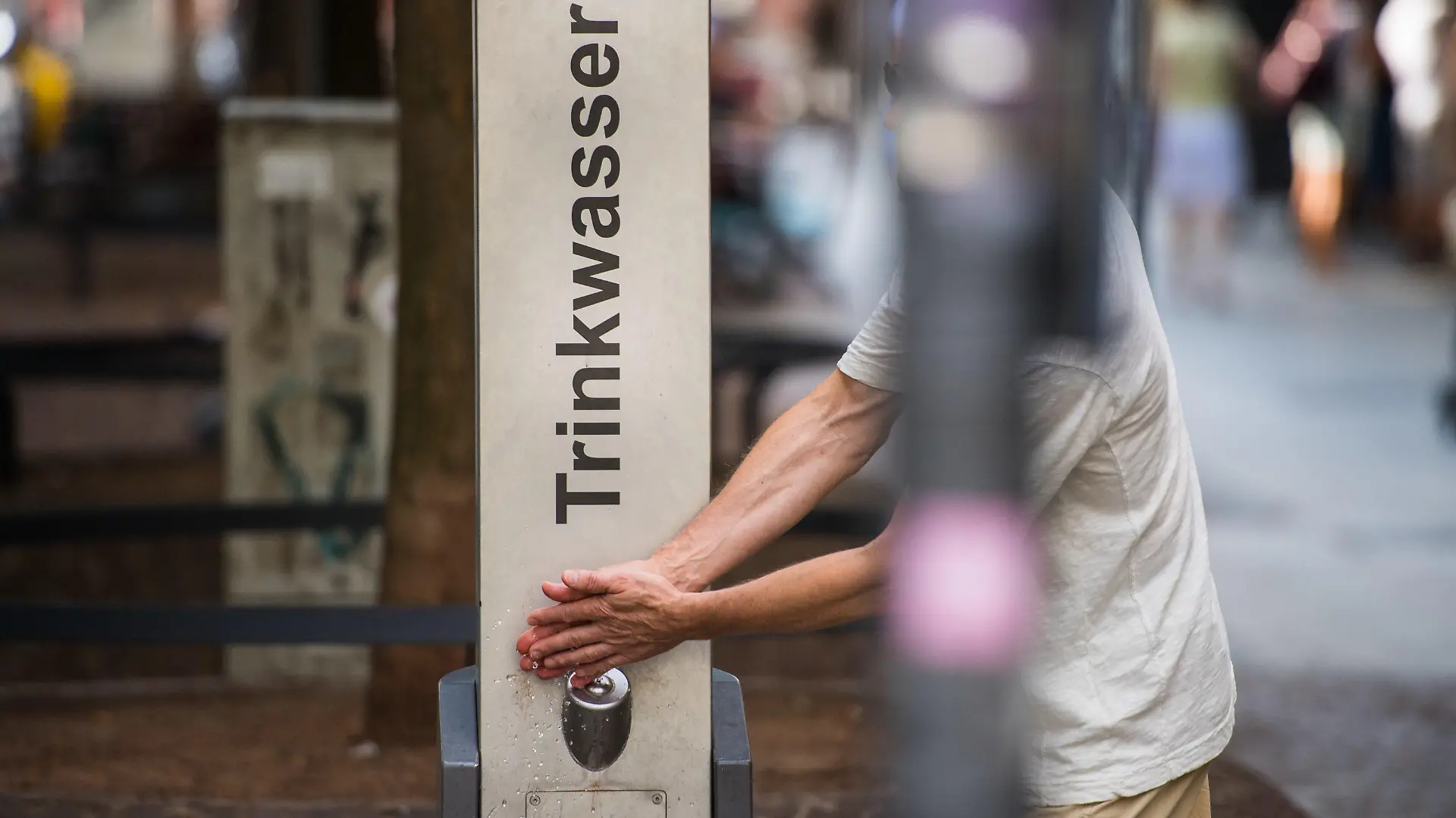 09.08.2018, Hessen, Frankfurt am Main: Ein Mann nutzt das kostenlose Trinkwasser an einem Brunnen zum Händewaschen. Der Trinkbrunnen wird von dem Frankfurter Energieversorger Mainova betrieben und steht in der Fußgängerzone. Die Non-Profit-Organisation "Refill Deutschland" wurde 2017 gegründet und setzt sich für die Vermeidung von Plastikmüll ein. In sogenannte Refill-Stationen (Geschäfte, Restaurants, Büros) kann kostenlos Leitungswasser in mitgebrachte Trinkflaschen abgefüllt werden. Auch in Frankfurt gibt es inzwischen mehrere Anlaufstellen. Foto: Andreas Arnold/dpa +++ dpa-Bildfunk +++