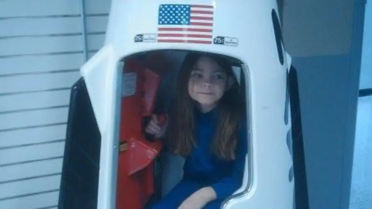 Alyssa sitzt als kleines Mädchen in einer Modell-Rakete
