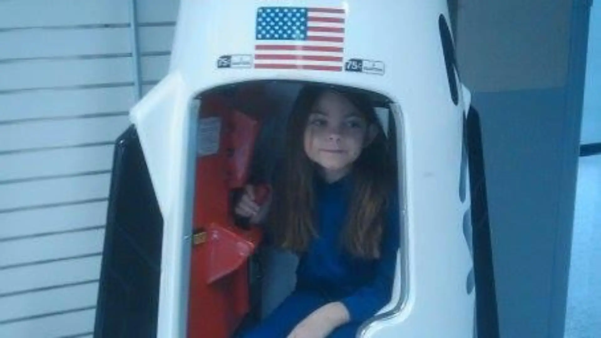 Alyssa sitzt als kleines Mädchen in einer Modell-Rakete