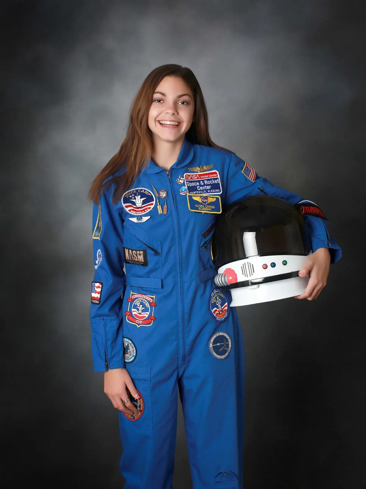 Die junge Frau posiert mit einem blauen NASA-Anzug und einem Weltraum-Helm