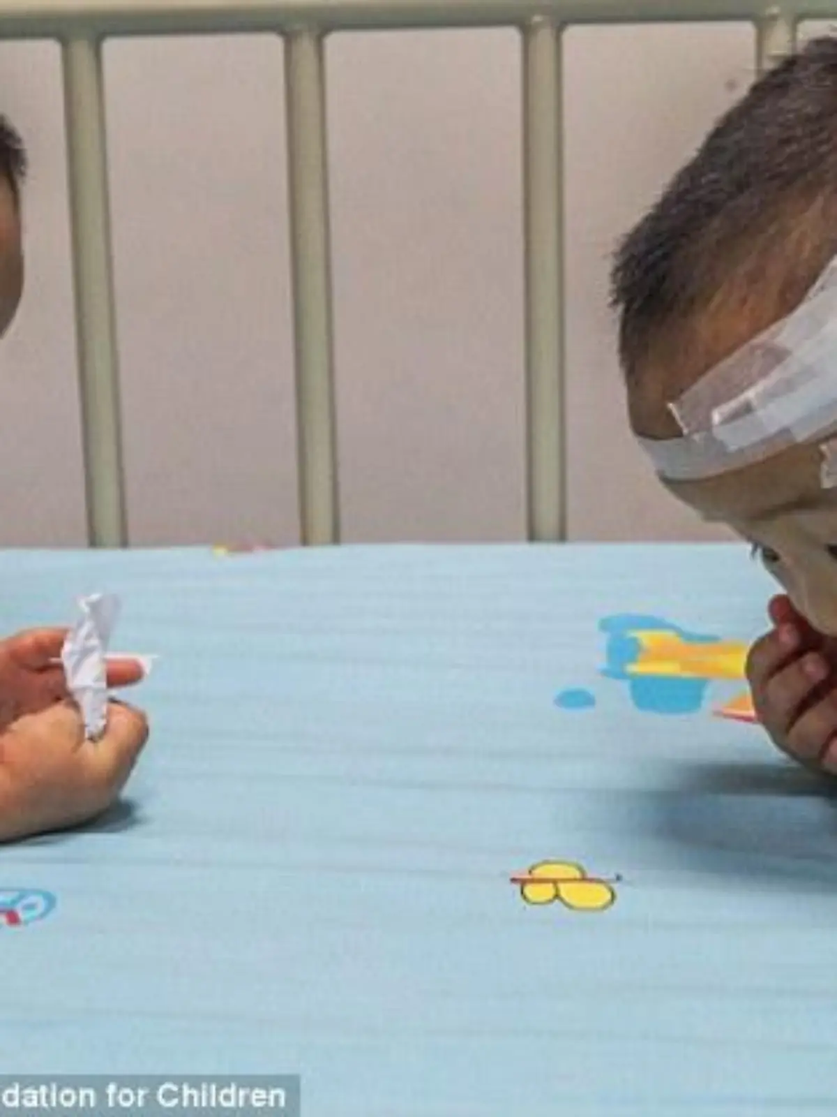 Die todkranken Zwillinge Kangkang und Lele aus China ziehen ein Los, das über eine Transplantation entscheiden soll.