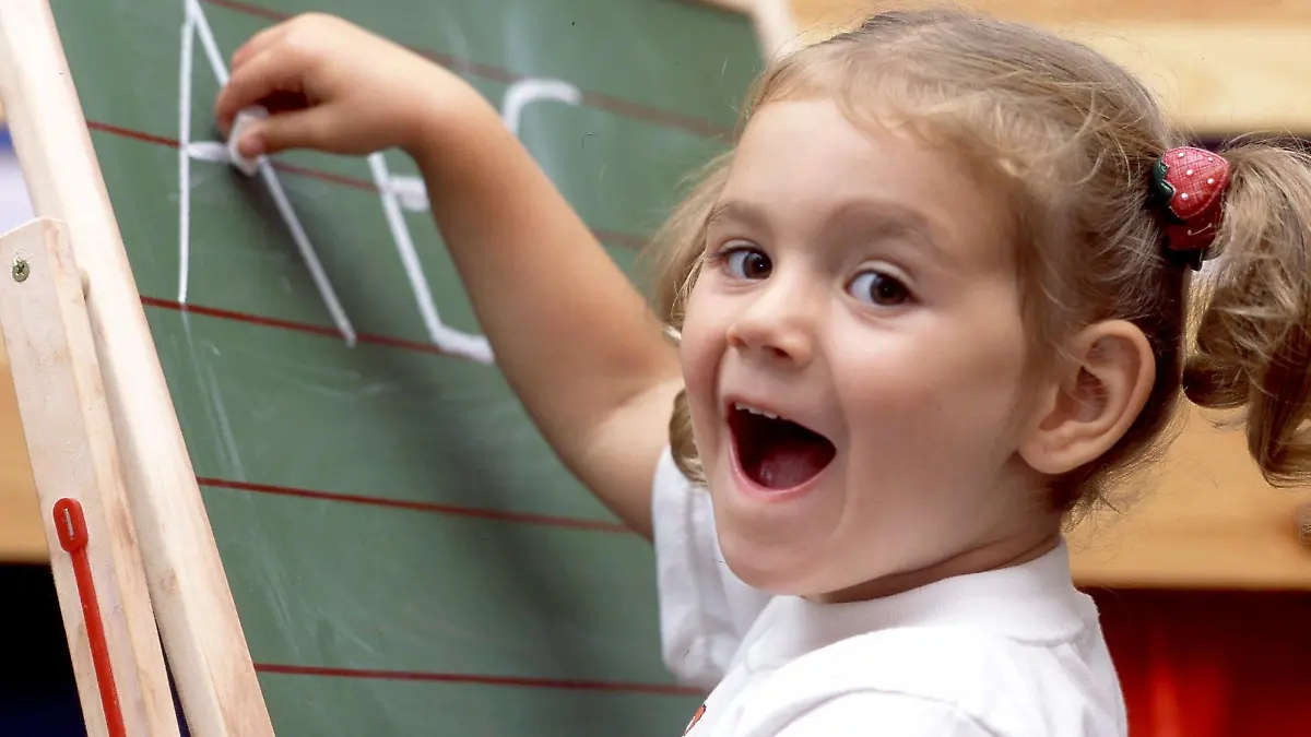 Mit Eifer schreibt dieses fünfjährige Mädchen bei dem gestellten Symbolbild die Buchstaben A B und C mit Kreide auf eine Schultafel, aufgenommen am 5.9.2003. Angesichts zunehmender Leseschwäche bei Kindern fordert die Stiftung Lesen in den Kindergärten verbindliche Tests zur Sprachfähigkeit. Nur auf Grundlage solcher Untersuchungen könne den Kindern frühzeitig gezielt und individuell geholfen werden. Rund 20 Prozent der Einschulungskinder haben Sprachentwicklungsprobleme, so die Stiftung. Später Folgen sind gravierende Lese- und Schreibeschwächen auch nach mehrjährigem Schulbesuch. Etwa vier Millionen Erwachsene in Deutschland können Schätzungen zufolge nicht richtig lesen und schreiben, obwohl sie die Schule besucht haben.