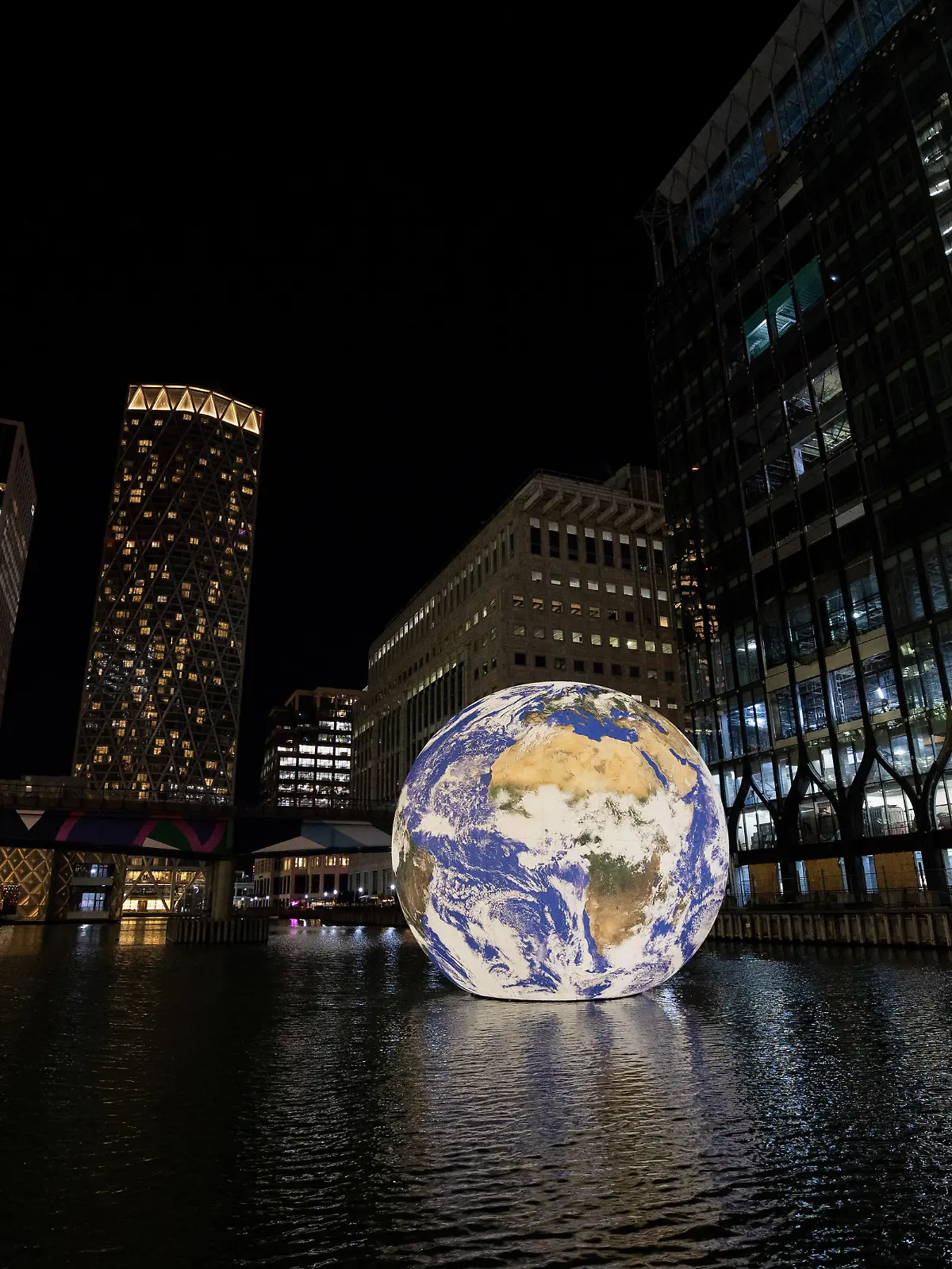 January 16, 2023, London, United Kingdom: The Floating Earth, light installation by Luke Jerram, in the Middle Dock at Canary Wharf. A giant magical globe floats in the water of Middle Dock at Canary Wharf as part of the exhibition of the Winter Lights festival after a two-year on hold due to COVID pandemic. The festival will start on Wednesday, January 18 to Saturday, January 28. (Credit Image: © Hesther Ng/SOPA Images via ZUMA Press Wire