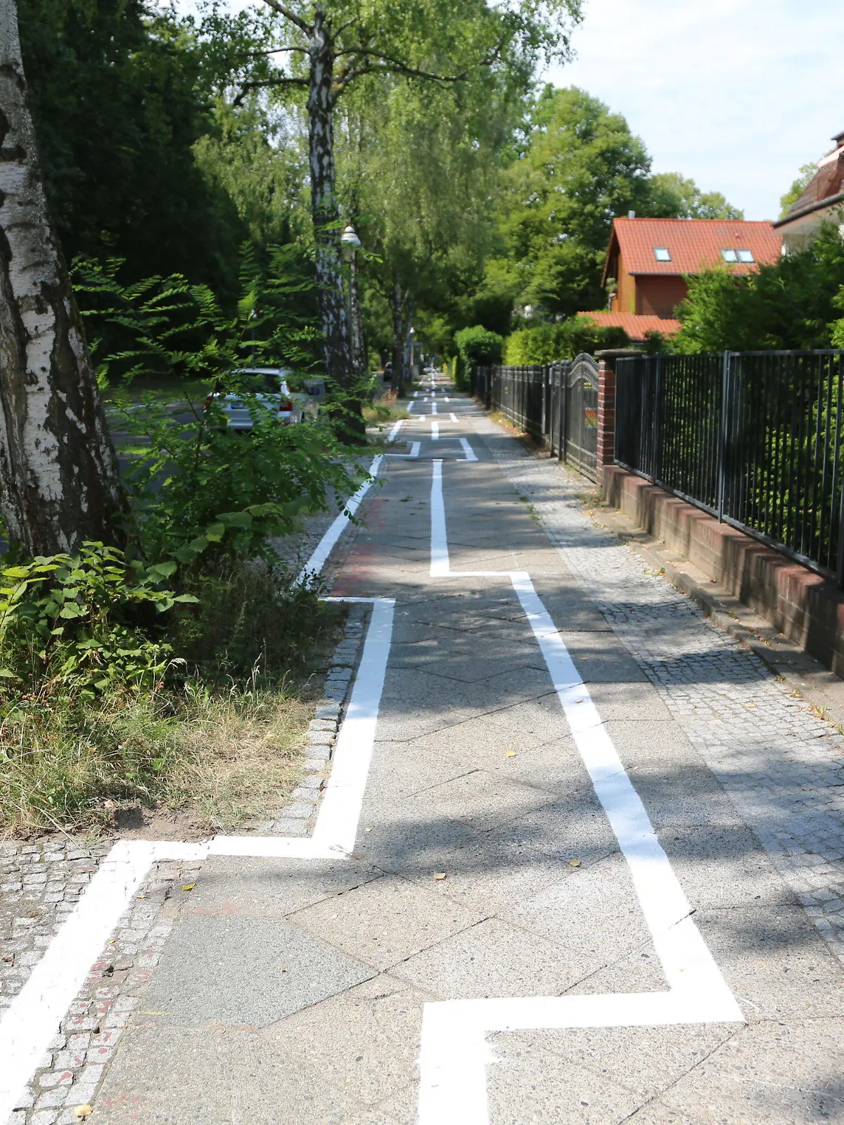 08.08.2018, Berlin: Im Zickzack verläuft ein Radweg im Stadtteil Zehlendorf. Die Markierungen sind jeweils in Höhe der Bäume verrückt. (zu dpa "«Eigentlich ganz hübsch» - Berlins neuer Gaga-Radweg" vom 08.08.2018) Foto: Nico Tapia/dpa +++ dpa-Bildfunk +++