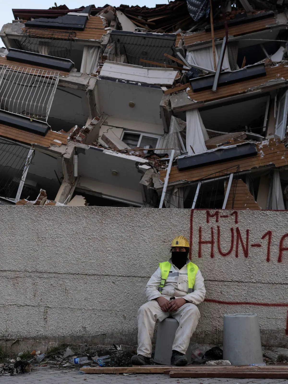 11.02.2023, Türkei, Antakya: Ein Rettungshelfer ruht sich aus, während andere die Suche nach den Opfern des Erdbebens fortsetzen. Die Zahl der Toten nach den verheerenden Erdbeben im türkisch-syrischen Grenzgebiet ist auf mehr als 25 000 gestiegen. Foto: Petros Giannakouris/AP/dpa +++ dpa-Bildfunk +++