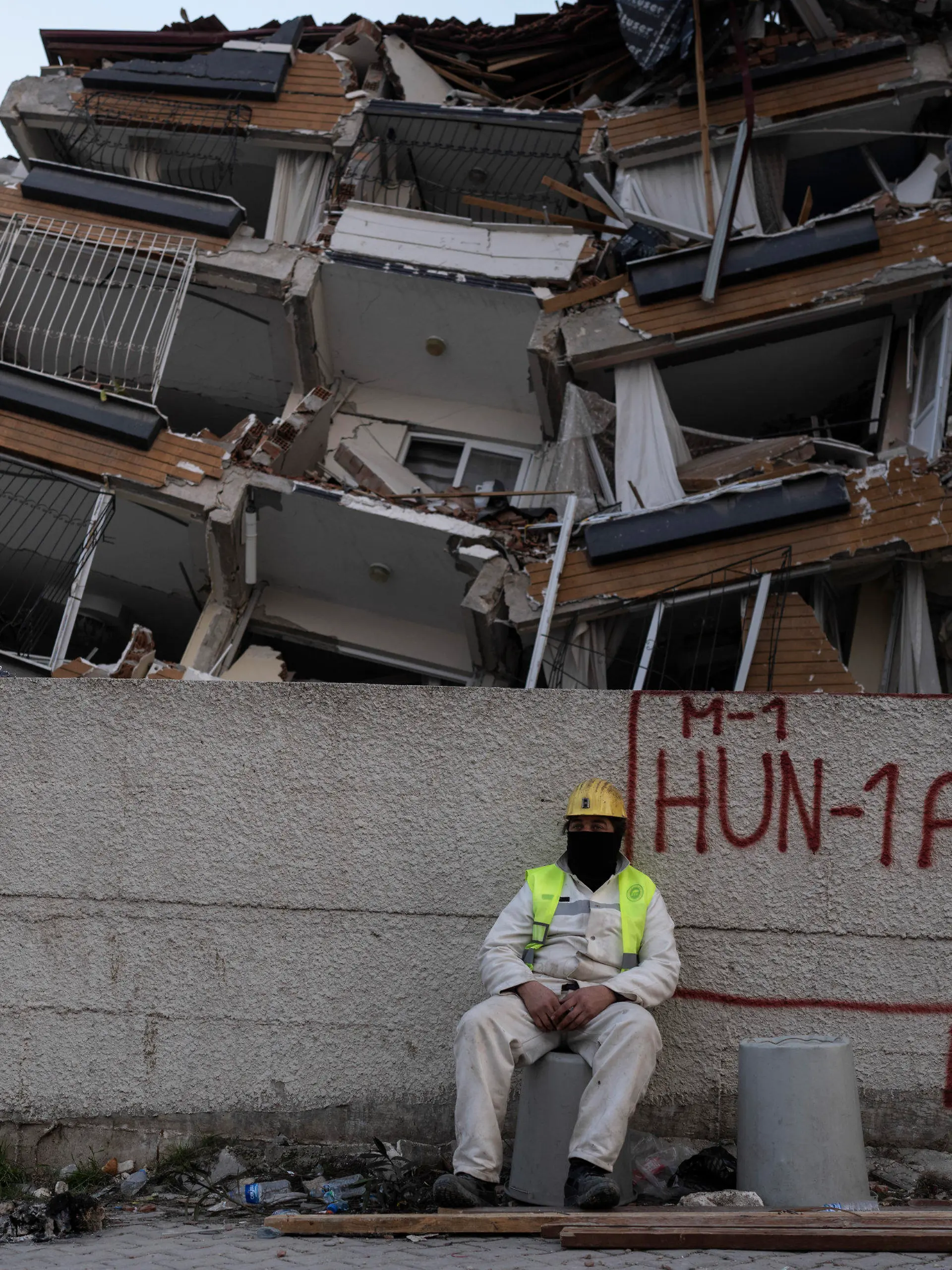 11.02.2023, Türkei, Antakya: Ein Rettungshelfer ruht sich aus, während andere die Suche nach den Opfern des Erdbebens fortsetzen. Die Zahl der Toten nach den verheerenden Erdbeben im türkisch-syrischen Grenzgebiet ist auf mehr als 25 000 gestiegen. Foto: Petros Giannakouris/AP/dpa +++ dpa-Bildfunk +++