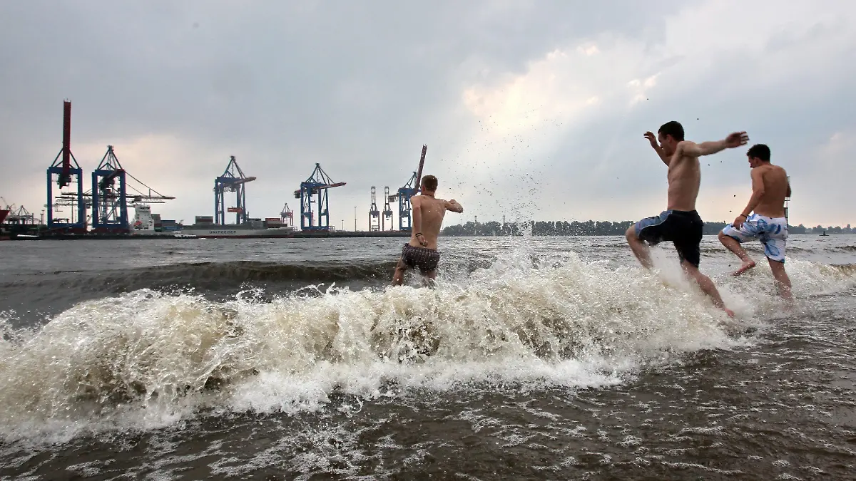 Drei Männer gehen am Montag (06.06.2011) bei einem aufziehenden Gewitter in der Elbe in Hamburg schwimmen. Starkregen hat am Montagabend in Hamburg zahlreiche Straßen unter Wasser gesetzt und Keller volllaufen lassen. Foto: Bodo Marks dpa/lno +++(c) dpa - Bildfunk+++
