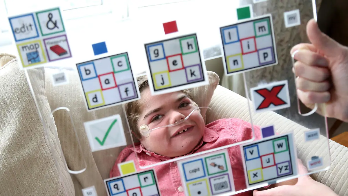 Jonathan Bryan mit einer Buchstabiertafel für nonverbale Kommunikation