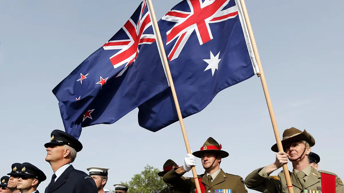 ARCHIV - 24.04.2014, Türkei, Canakkale: Soldaten aus Neuseeland und Australien stehen mit einer neuseeländischen (l) und einer australischen Flagge vor dem Mehmetcik Monument um an die Schlacht von Gallipoli zu erinnern. Der 25. April 1915 ist der Jahrestag der ersten Militäraktion von australischen und neuseeländischen Truppen sowie Soldaten aus Tonga im Ersten Weltkrieg - der Landung auf Gallipoli. Die Schlacht von Gallipoli führte unter den in einer Streitmacht geführten australischen, neuseeländischen und tongaischen Soldaten zu erheblichen Verlusten. (zu dpa «Flaggenstreit: Neuseelands Premier legt sich mit Australien an» vom 25.07.2018) Foto: Tolga Bozoglu/EPA/dpa +++ dpa-Bildfunk +++