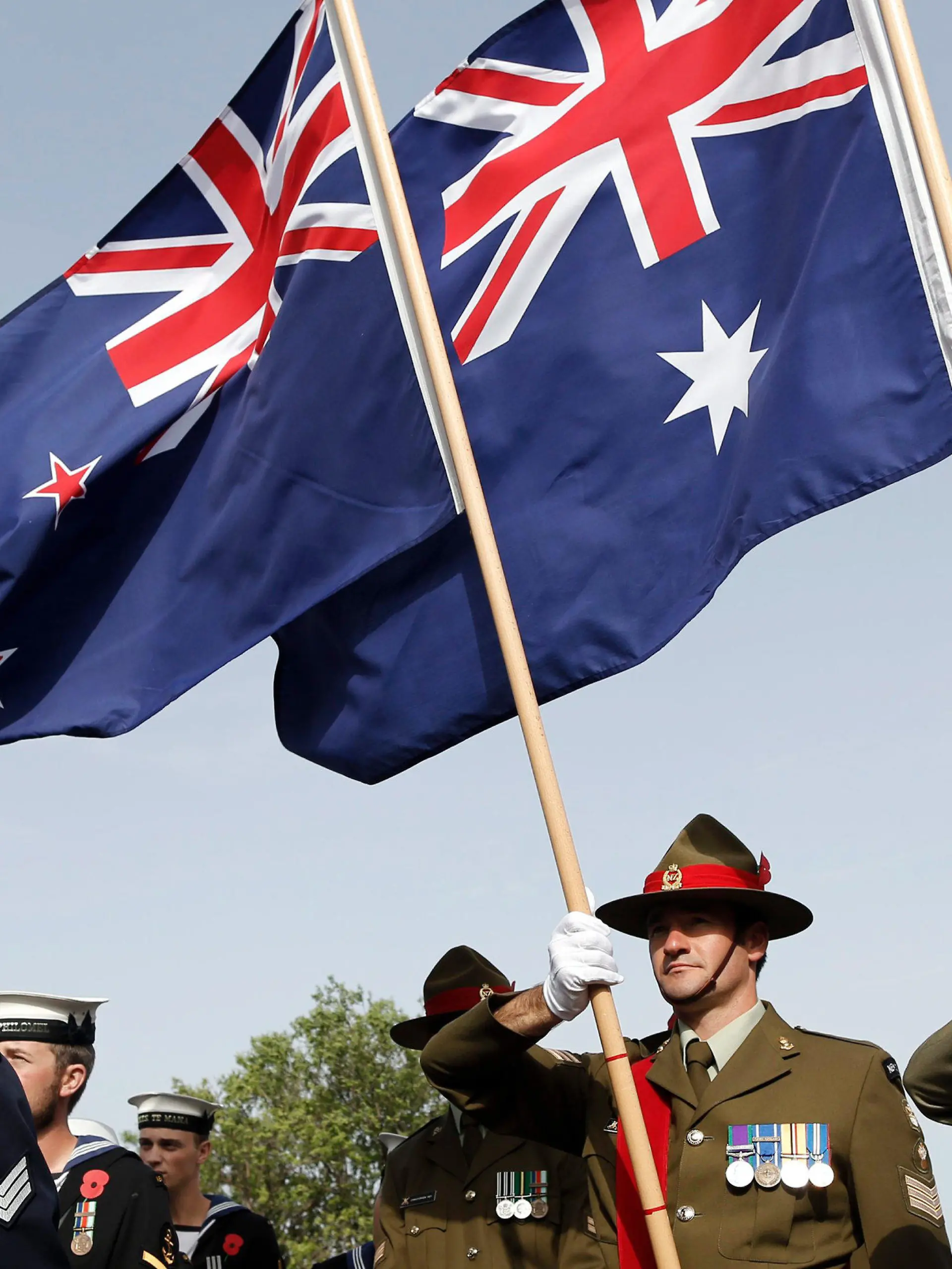 ARCHIV - 24.04.2014, Türkei, Canakkale: Soldaten aus Neuseeland und Australien stehen mit einer neuseeländischen (l) und einer australischen Flagge vor dem Mehmetcik Monument um an die Schlacht von Gallipoli zu erinnern. Der 25. April 1915 ist der Jahrestag der ersten Militäraktion von australischen und neuseeländischen Truppen sowie Soldaten aus Tonga im Ersten Weltkrieg - der Landung auf Gallipoli. Die Schlacht von Gallipoli führte unter den in einer Streitmacht geführten australischen, neuseeländischen und tongaischen Soldaten zu erheblichen Verlusten. (zu dpa «Flaggenstreit: Neuseelands Premier legt sich mit Australien an» vom 25.07.2018) Foto: Tolga Bozoglu/EPA/dpa +++ dpa-Bildfunk +++