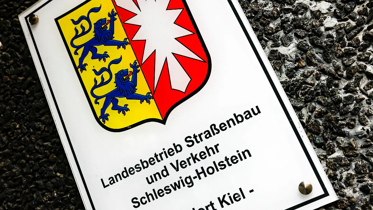 ARCHIV - 01.02.2023, Schleswig-Holstein, Kiel: Ein Hinweisschild auf den Sitz vom Landesbetrieb Straßenbau und Verkehr hängt am Eingang zur Hauptstelle. Die schleswig-holsteinische FDP kritisiert die geplante Umbenennung des Landesbetriebs. (zu dpa «210 000 Euro für die Streichung eines Wortes») Foto: Axel Heimken/dpa +++ dpa-Bildfunk +++